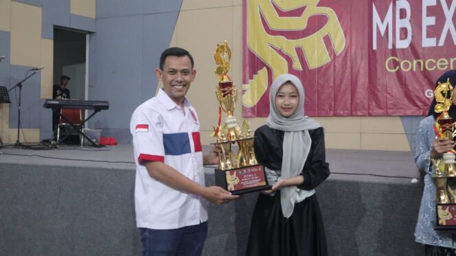 
 Ketua Federasi Youth Band Indonesia (FYBI) Kota Tangerang, Sanusi saat menyerahkan trophy kepada Juara Lomba Marching Band Extravaganza 2025 di Gedung Kesenian dan Kebudayaan Kota Tangerang. Foto: Ist
