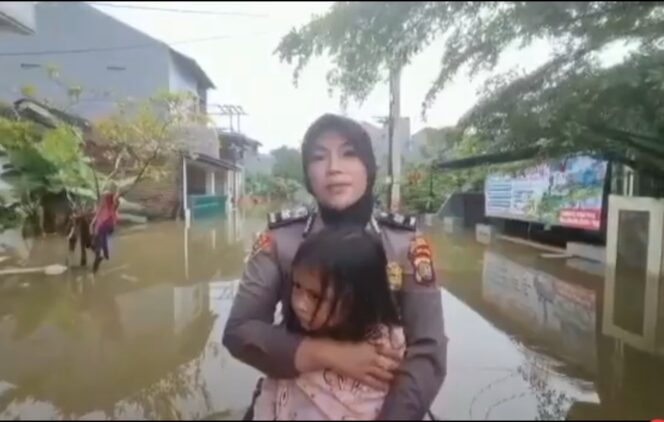 
 Aiptu Yiyik Istiqomah, Anggota Polwan Polsek Jatiuwung Polres Metro Tangerang Kota tengah memeluk erat seorang Balita saat di evakuasi ketempat pengungsian. Foto: Polsek Jatiuwung